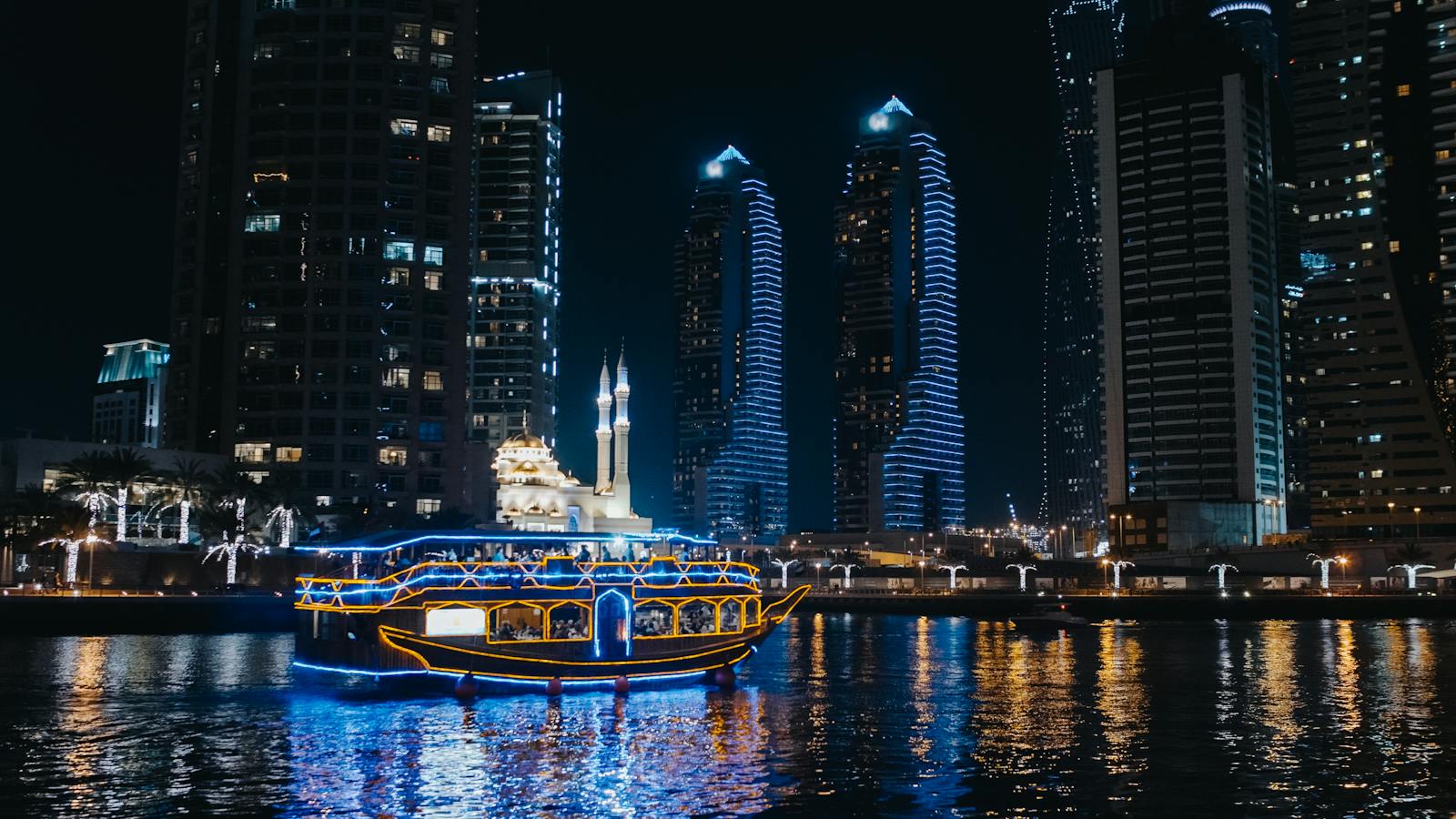 A Boat Sailing on River Near City Buildings during Night